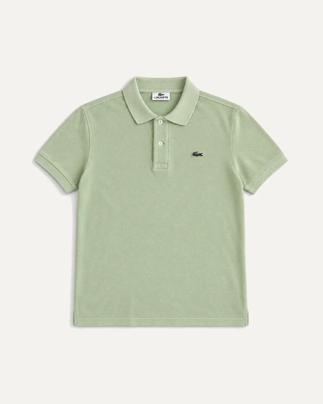 Polo verde menta de Lacoste presentado completo sobre fondo neutro
